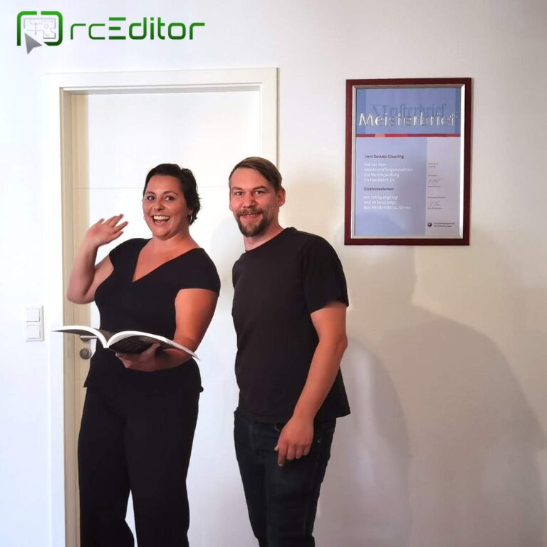 Zwei Menschen stehen lächelnd vor einer Tür: Rebecca Hümmer & Donato Clausing.